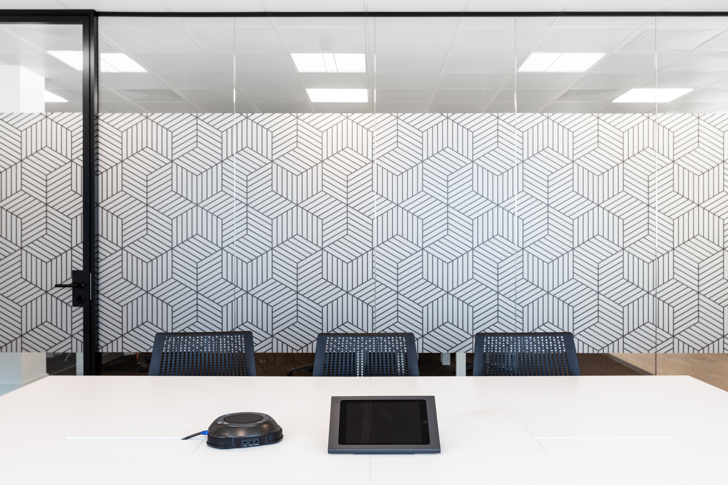 A close-up of a sleek, patterned glass wall within the Ring Central office, adding a stylish and modern touch to the meeting room design.