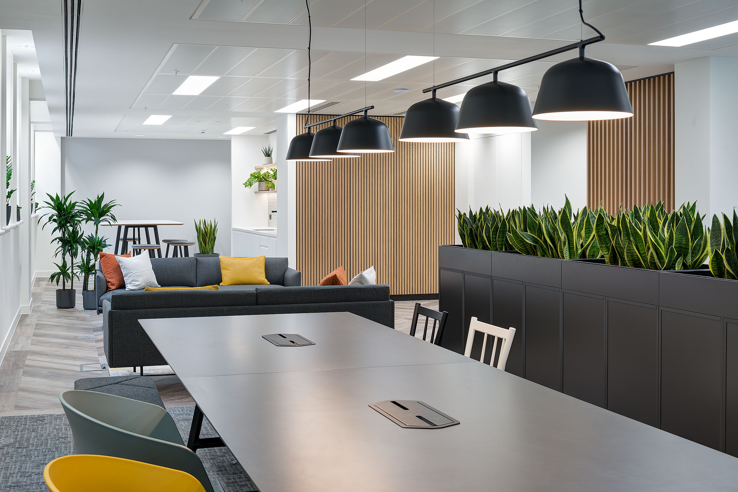 Breakout space at 20 St James Street Level 1, with sofas and a communal table, designed for informal meetings and social interaction.