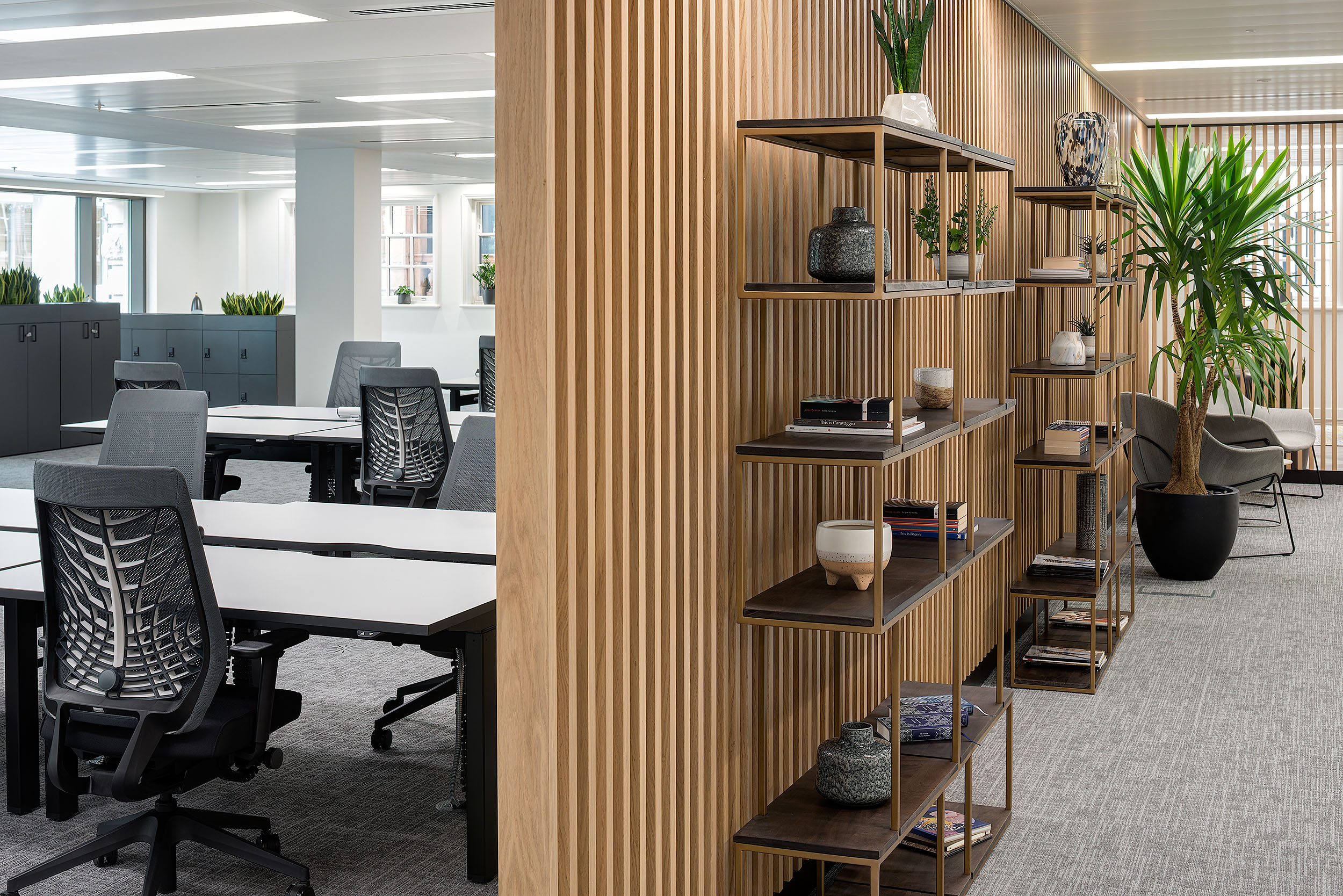 Wood-panelled partition with shelving and plants at 20 St James Street Level 1, providing a stylish division within the open office space