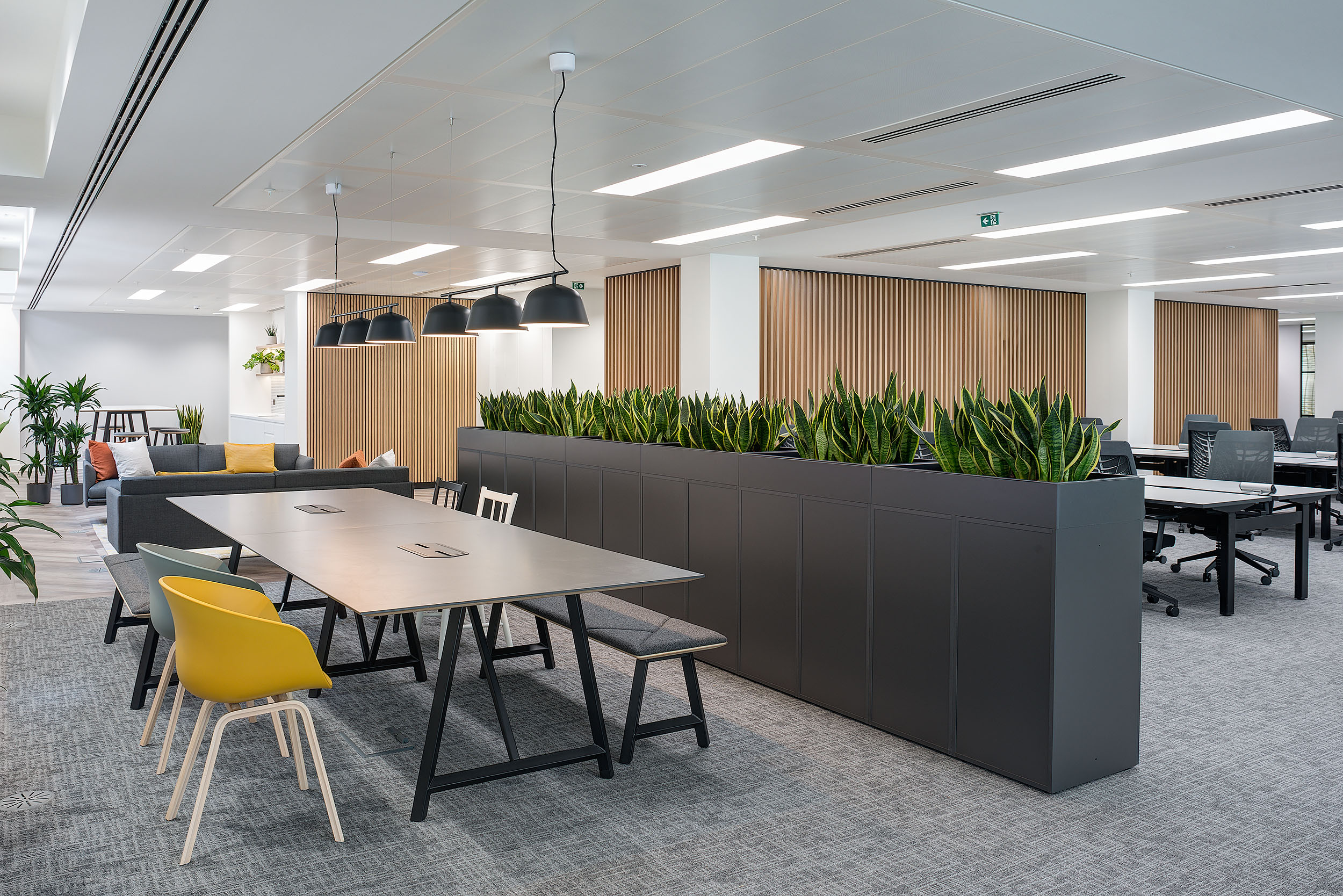 Collaborative area at 20 St James Street Level 1, with a large communal table, bench seating, and pendant lighting for a versatile workspace.