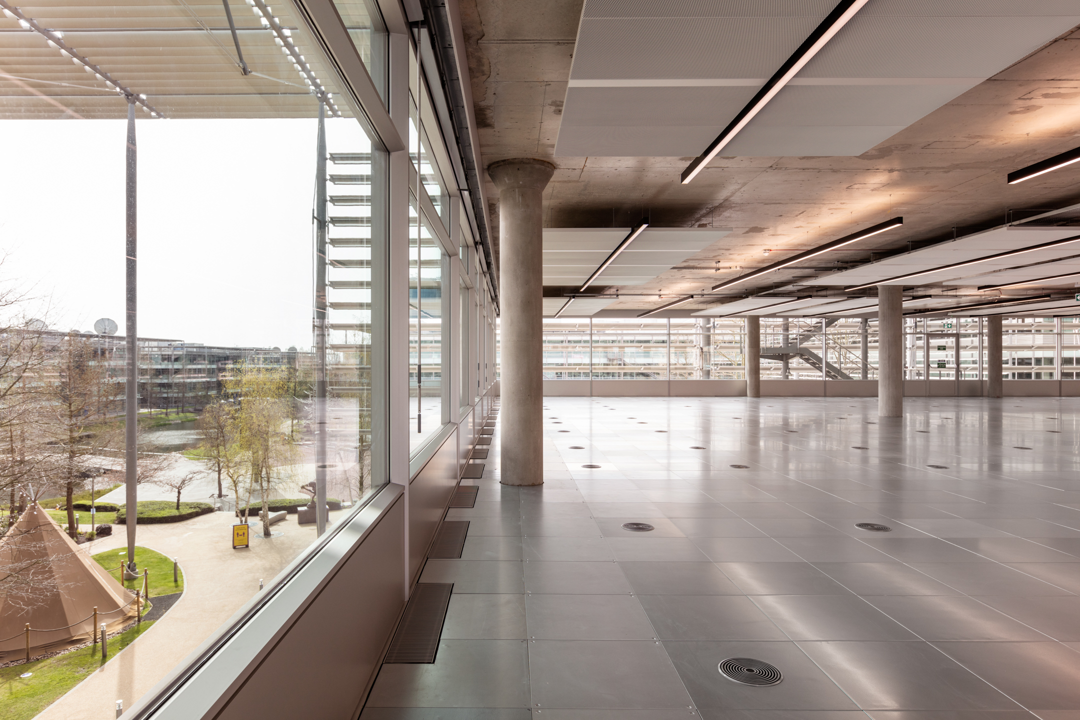 Chiswick Business Park Building 5 with Views Overlooking the Park: An interior shot of Chiswick Building 5, showing the modern workspace with floor-to-ceiling windows that provide views of the park outside, including trees and open green spaces.