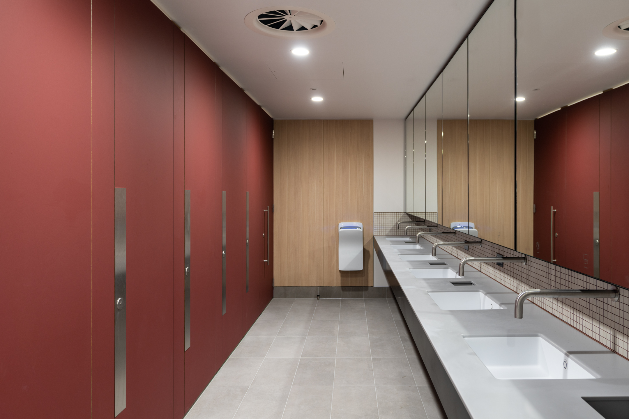 Modern bathroom facilities at Chiswick Business Park Building 12 featuring red partitions and sleek design - Cat-A fit-out