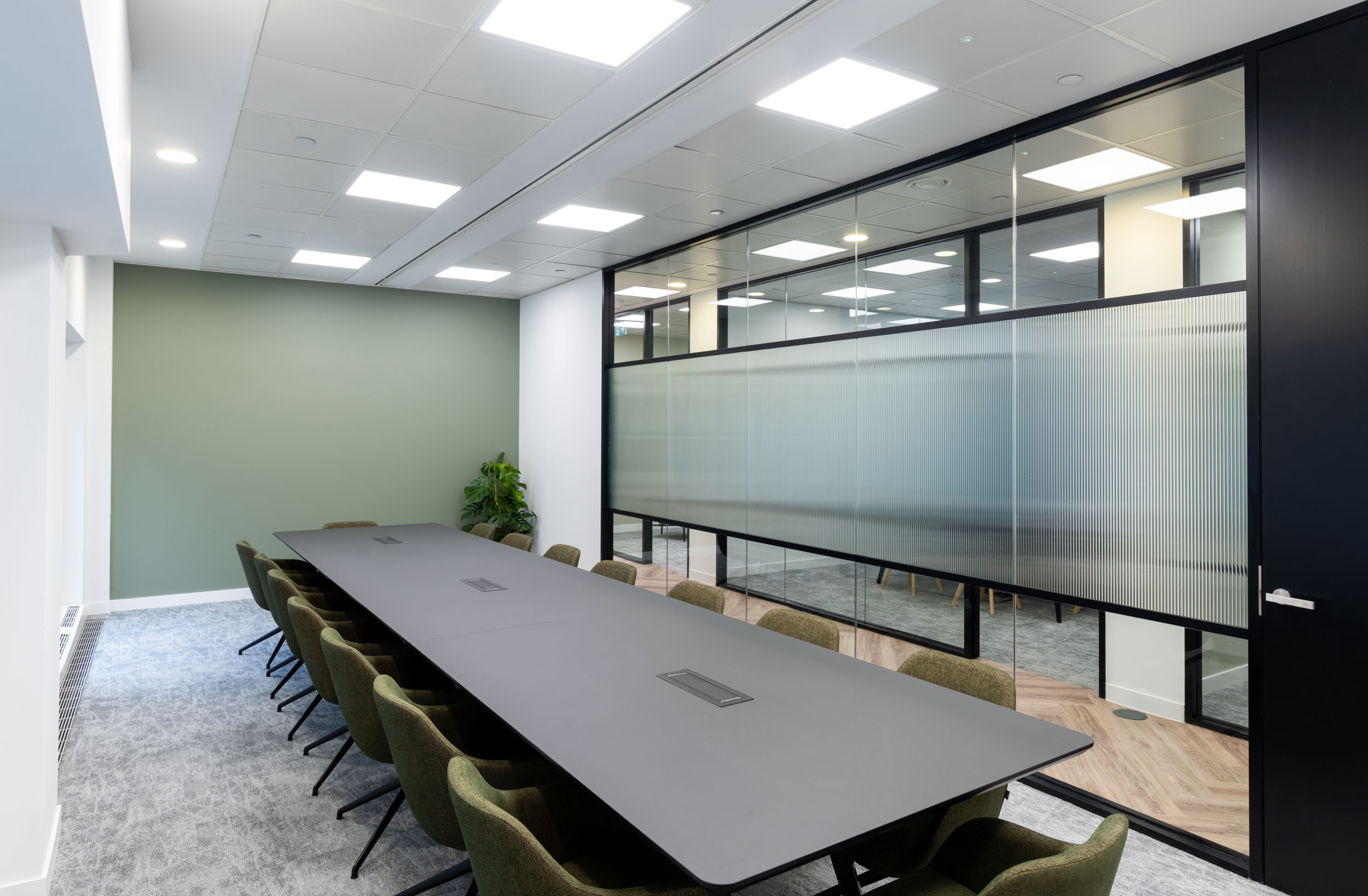 Sleek meeting room with privacy glass and green feature wall at One Strand - Tenant-Ready™ fit-out by Ambit