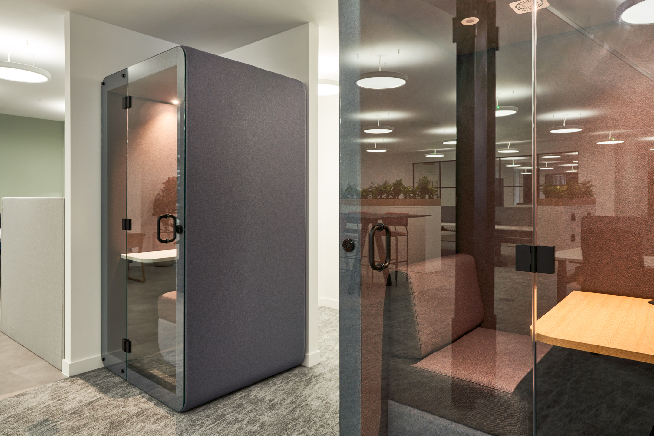 Private acoustic pods at 3 St Helens Place, designed for focused work, featuring comfortable seating and glass doors within an open-plan office setting.