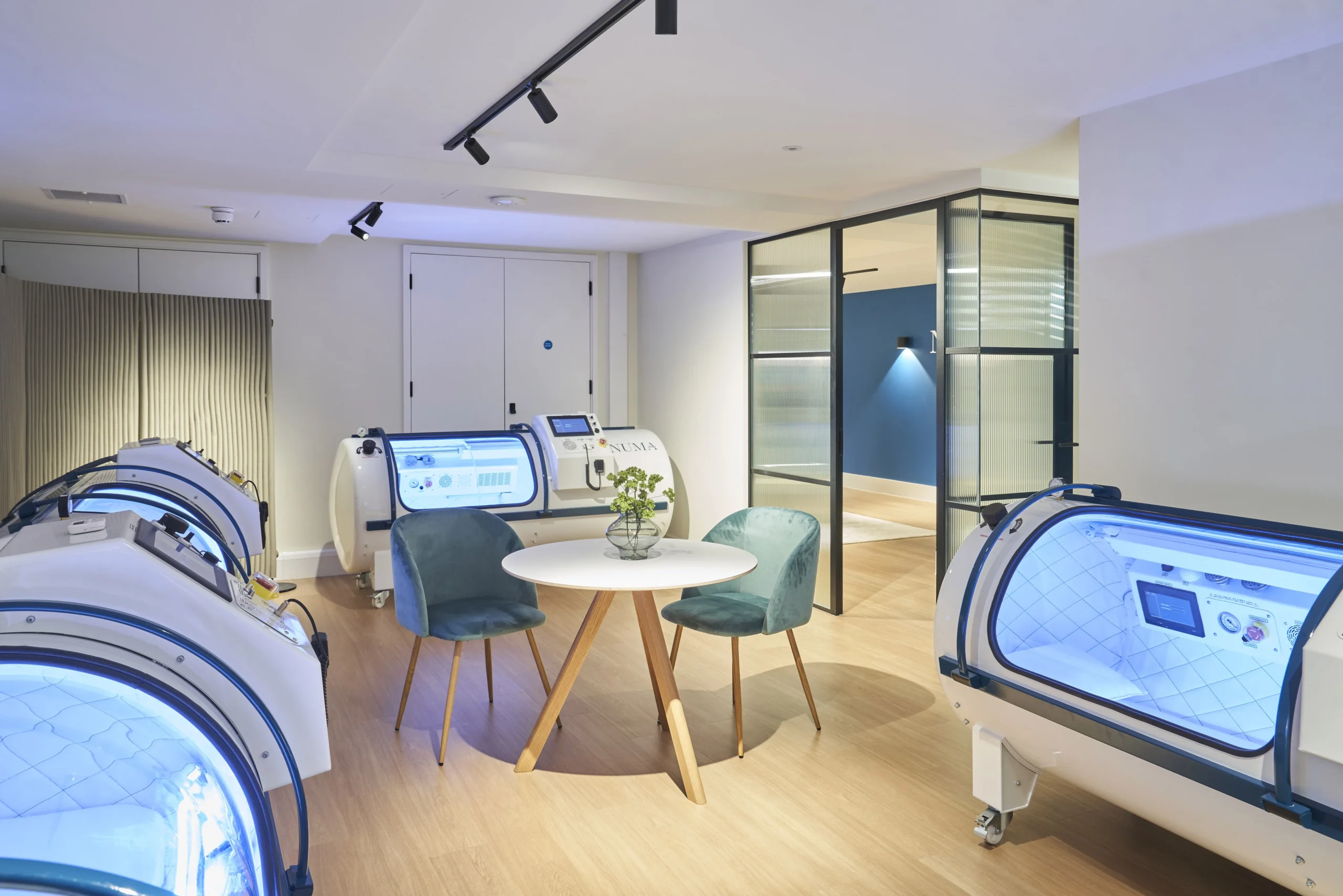 Hyperbaric oxygen therapy room at Numa with modern seating and capsule chambers - designed by Ambit