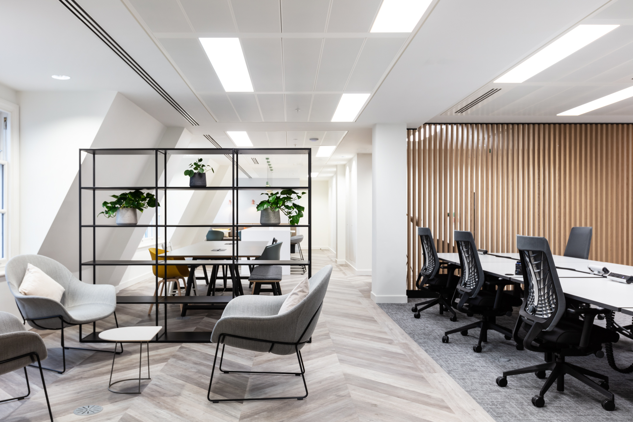 Modern office space at 20 St James’s Street, Level 8 with lounge seating, open shelving, and a collaborative workspace featuring stylish chairs and natural lighting.