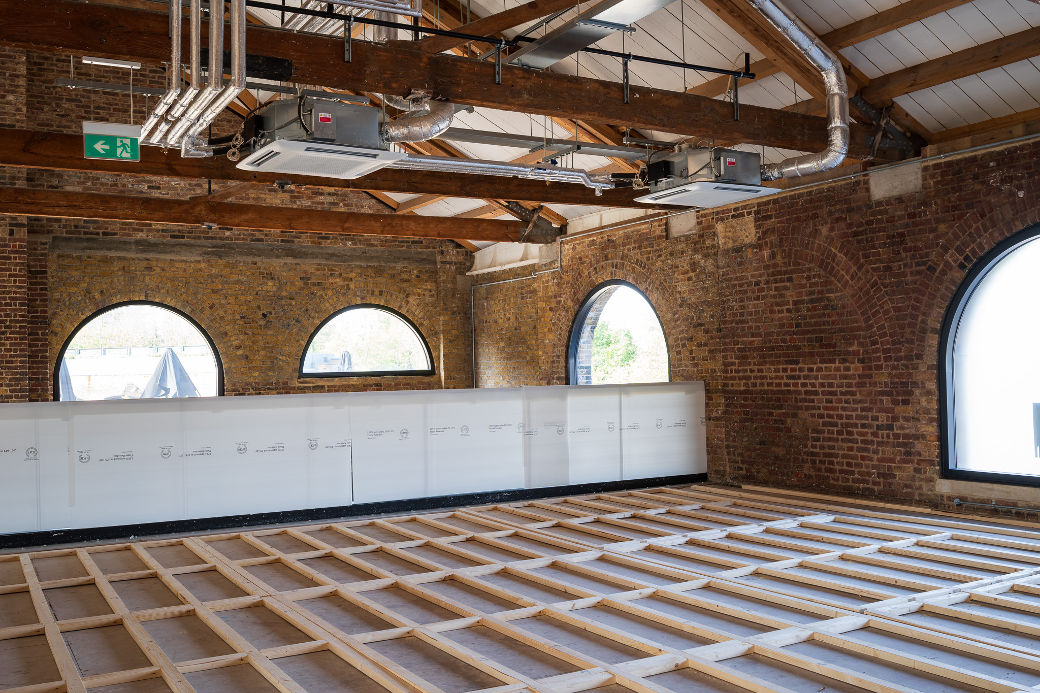 Beams layered on the floor at Coal Drops Yard with an exposed ceilinig