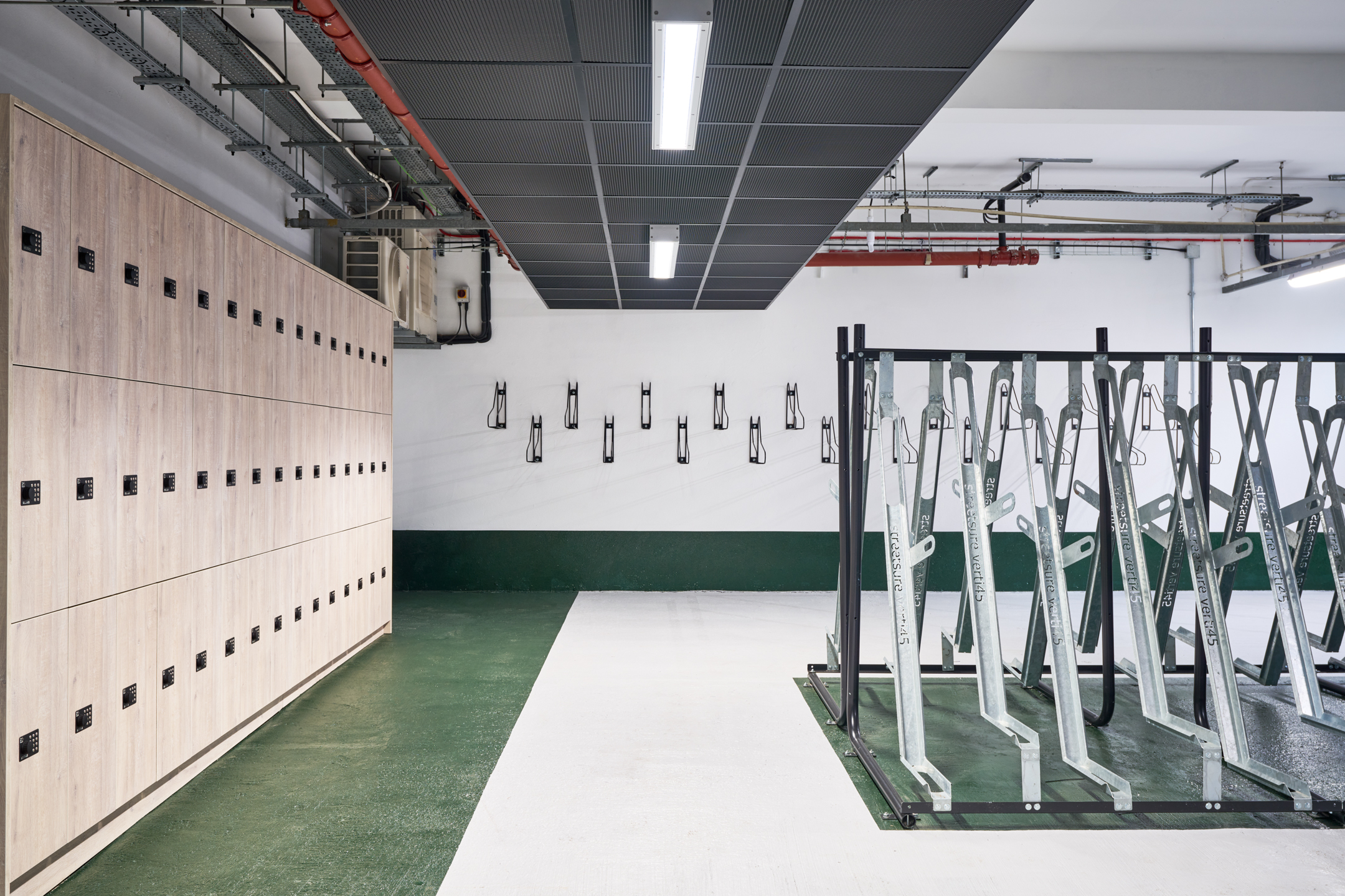 Bike storage area at 163-203 Eversholt Street, featuring lockers and metal bike racks, in a well-organised industrial-style space.