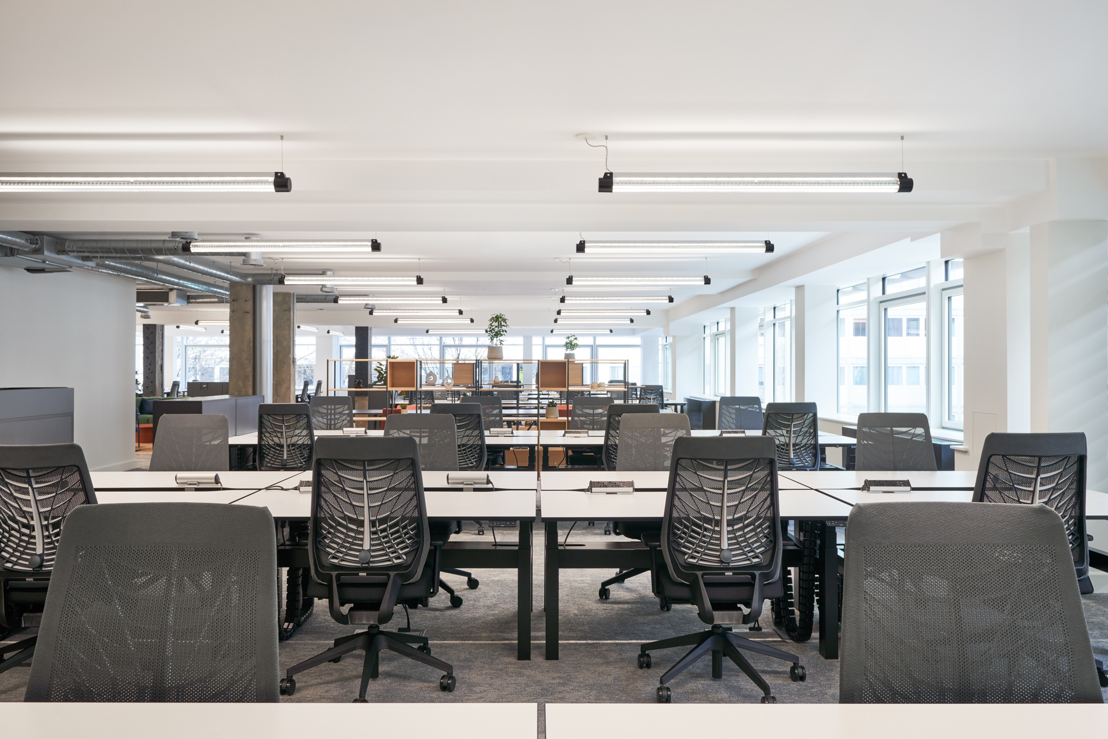 Ergonomic workstations at 101 New Cavendish Street, L2, featuring rows of white desks and black chairs in an open and bright layout.