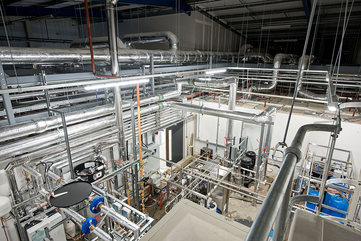 Industrial piping and ventilation system at Smiths Detection, showcasing extensive network of insulated ducts and mechanical equipment for effective air and temperature management within the facility.