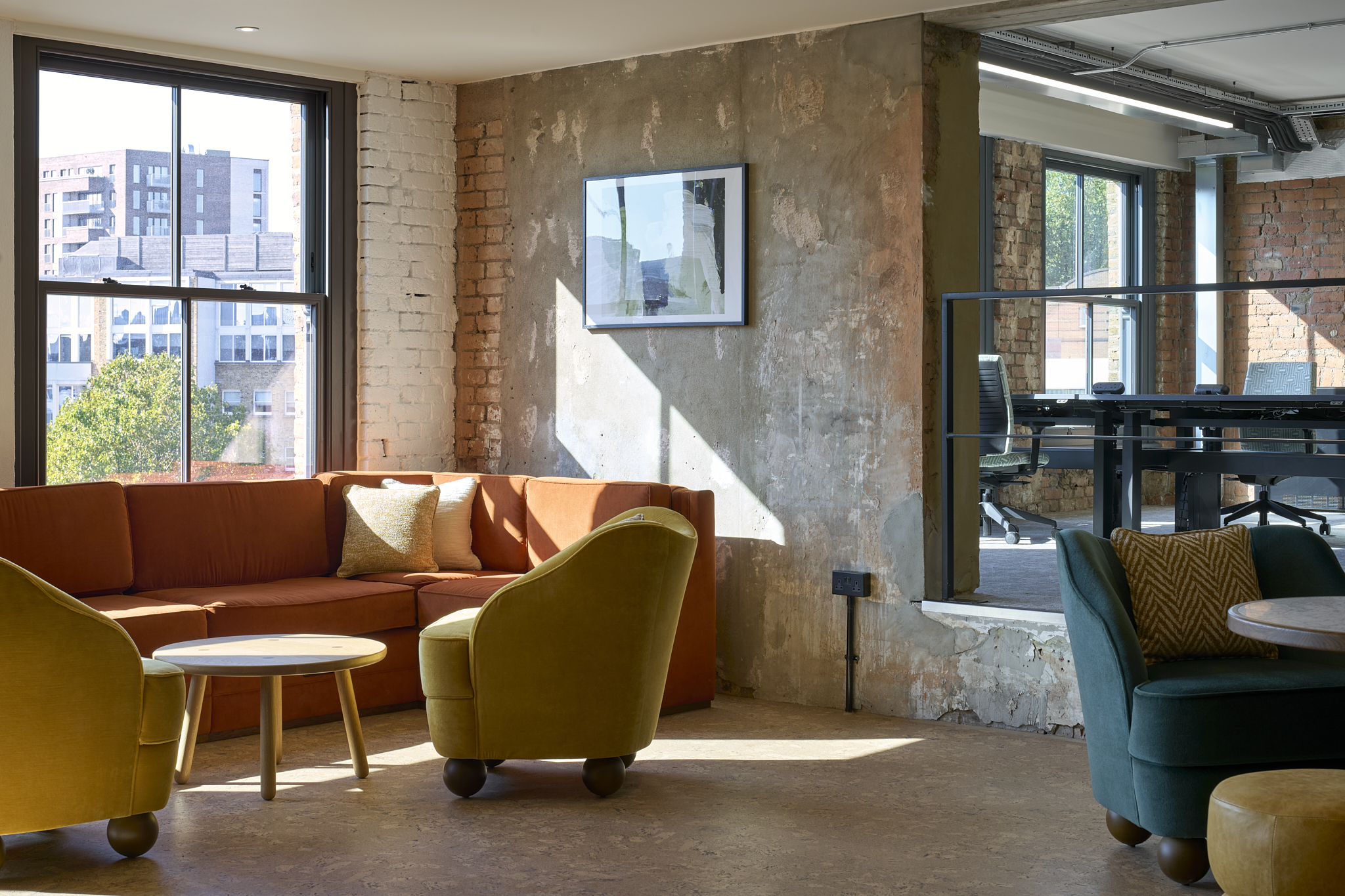 Brick wall featuring an orange sofa and yellow chairs