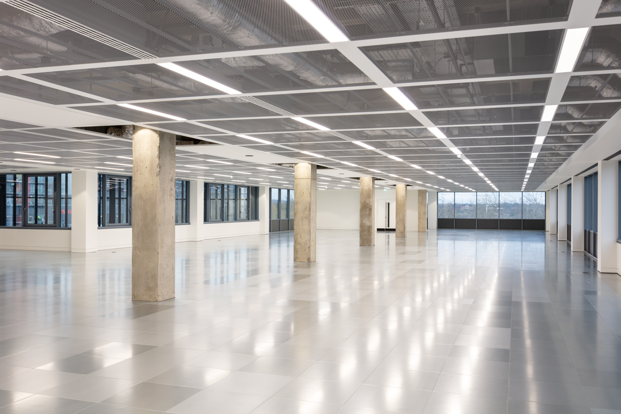 Another view of the expansive office space at Witan Gate, showing the ceiling with integrated lighting and multiple concrete columns throughout the floor.