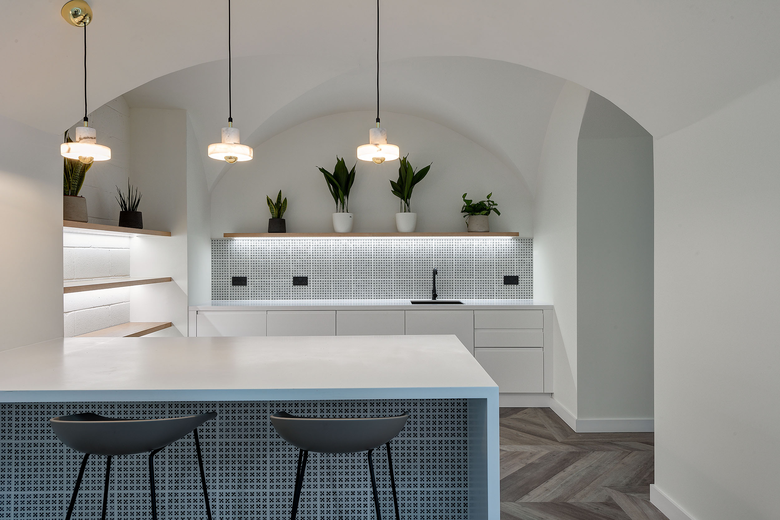 White teapoint with blue accents, hanging lighting, and biophilic plants with dome-like ceilings